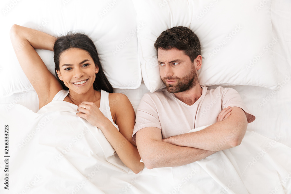 Displeased quarrel young loving couple lies in bed under blanket. Displeased quarrel young loving couple lies in bed under blanket.