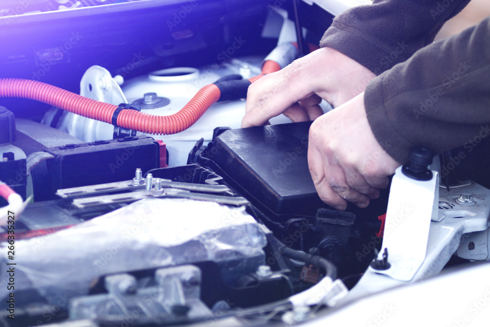 Mechanic checking the car fuse of electric car. Mechanic checking the car fuse of electric car.