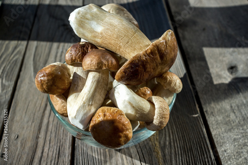 Autumn fresh boletus mushrooms in a bowl on a wooden background. Cooking delicious organic mushroom.