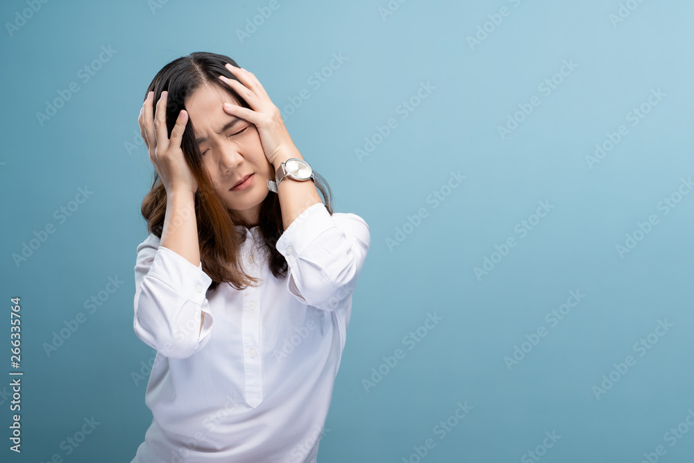 Woman has headache isolated over blue background Woman has headache isolated over blue background