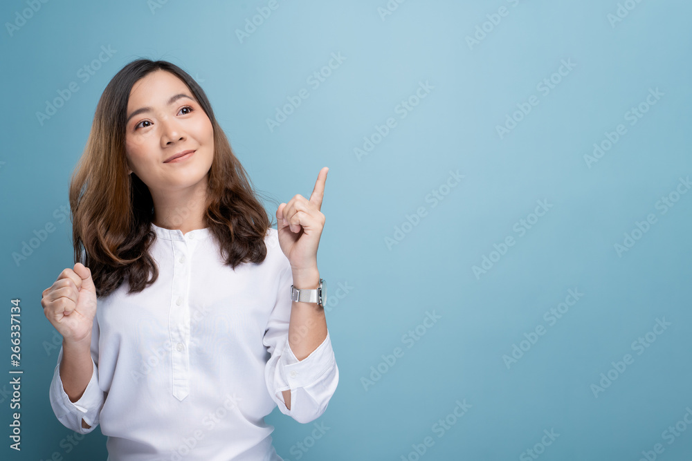 Happy woman thinking and standing isolated over blue background Happy woman thinking and standing isolated over blue background