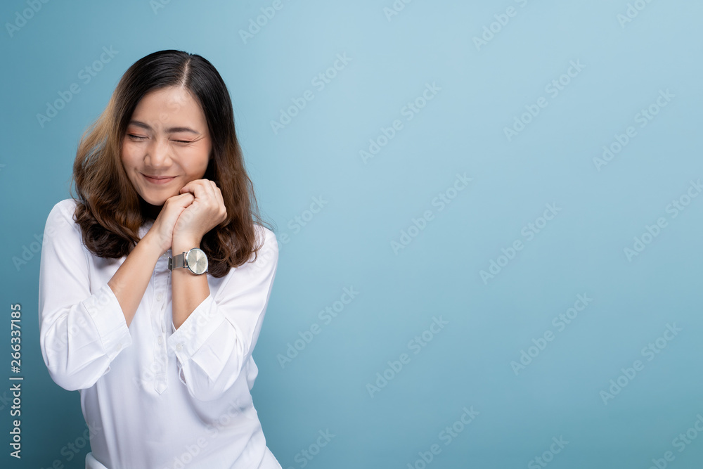 Happy woman thinking and standing isolated over blue background Happy woman thinking and standing isolated over blue background