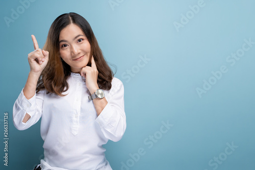 Happy woman thinking and standing isolated over blue background