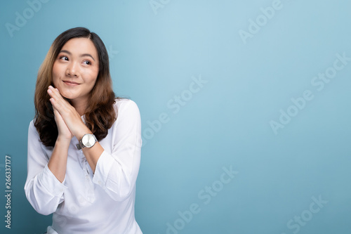 Happy woman thinking and standing isolated over blue background