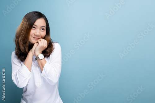 Happy woman thinking and standing isolated over blue background