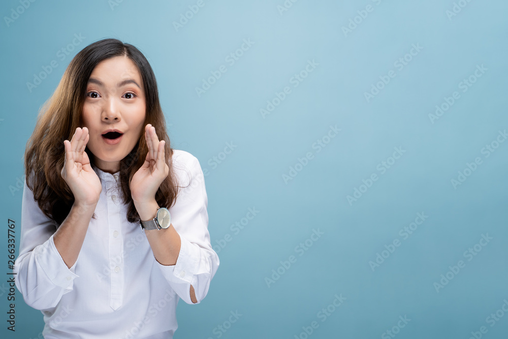 Woman make gossip gesture isolated over blue background Woman make gossip gesture isolated over blue background