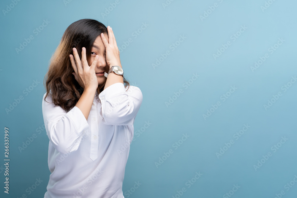 Woman feel scared standing isolated over blue background Woman feel scared standing isolated over blue background