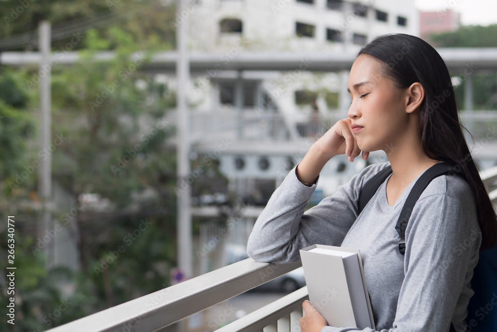 Fototapeta premium portrait of stressed, serious, pensive, thoughtful asian woman college student thinking in city campus environment