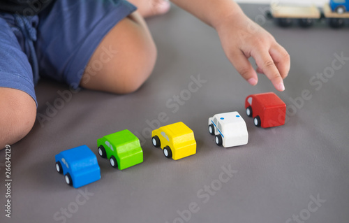 Close up of a child hand playing wooden car