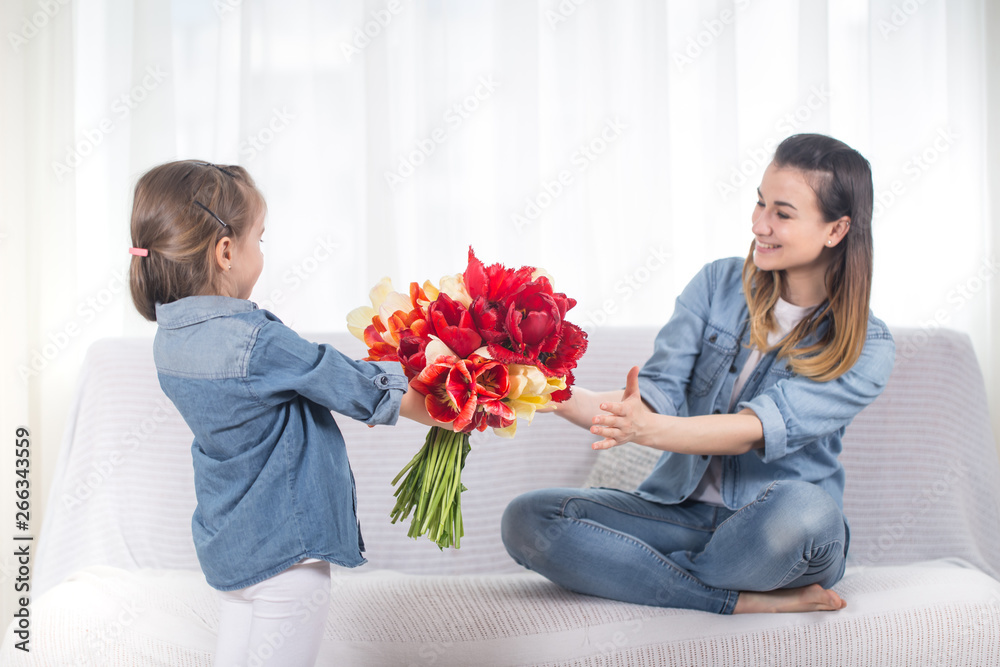 Mother's day. Little daughter with flowers congratulates her mother Mother's day. Little daughter with flowers congratulates her mother