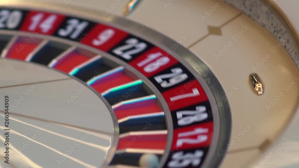 Roulette table in casino, with many games and slots, roulette wheel in the foreground. Golden and luxury light, casino interior. Gambling is the wagering of money or playing games of chance for money Roulette table in casino, with many games and slots, roulette wheel in the foreground. Golden and luxury light, casino interior. Gambling is the wagering of money or playing games of chance for money