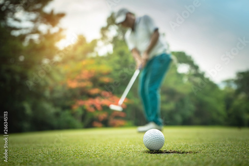 Fototapeta Działanie golfisty, aby wygrać po długim umieszczeniu piłki golfowej na zielonym polu golfowym