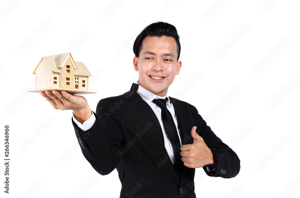 Studio portrait of handsome and confident young real estate agent on white background holding house model Studio portrait of handsome and confident young real estate agent on white background holding house model