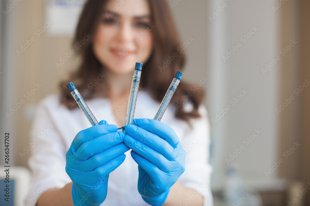 Young attractive doctor with syringes. Close up portrait of cosmetologist holding medical tools. Doctor in the clinic or hospital. Nurse going to make an injection. Young attractive doctor with syringes. Close up portrait of cosmetologist holding medical tools. Doctor in the clinic or hospital. Nurse going to make an injection.