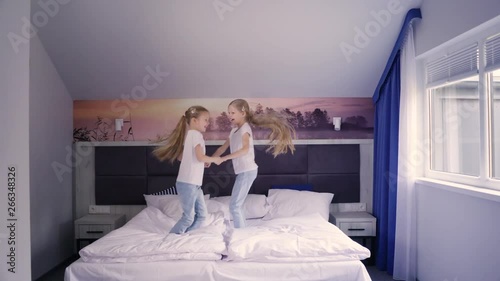 Cheerful twins jumping on bed