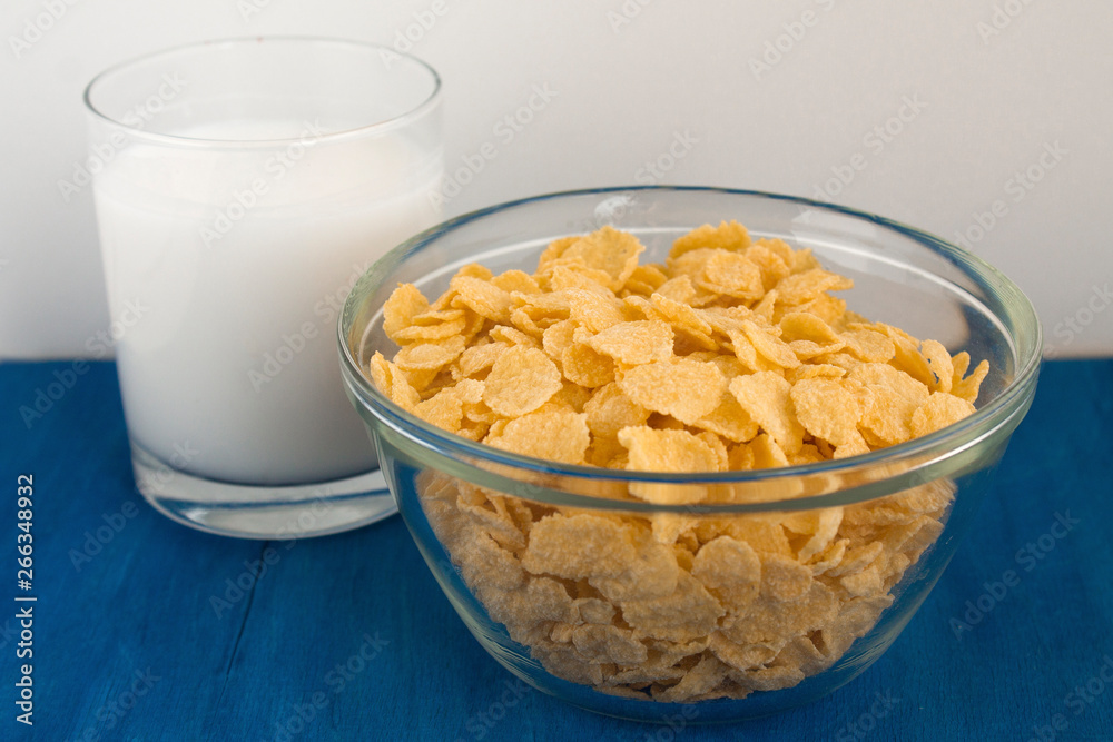 Cornflakes with milk for breakfast. Blue background. Cornflakes with milk for breakfast. Blue background.