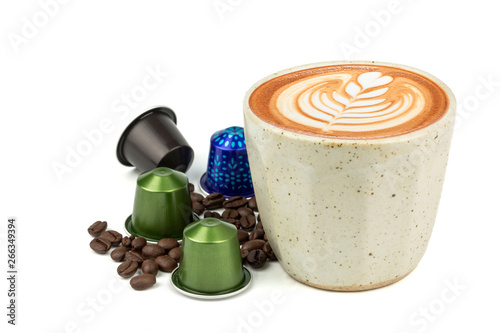 Side view of Hot latte coffee and latte art in a vintage cup with aluminum capsules and roasted coffee beans isolated on white background. (Image stacking technique)