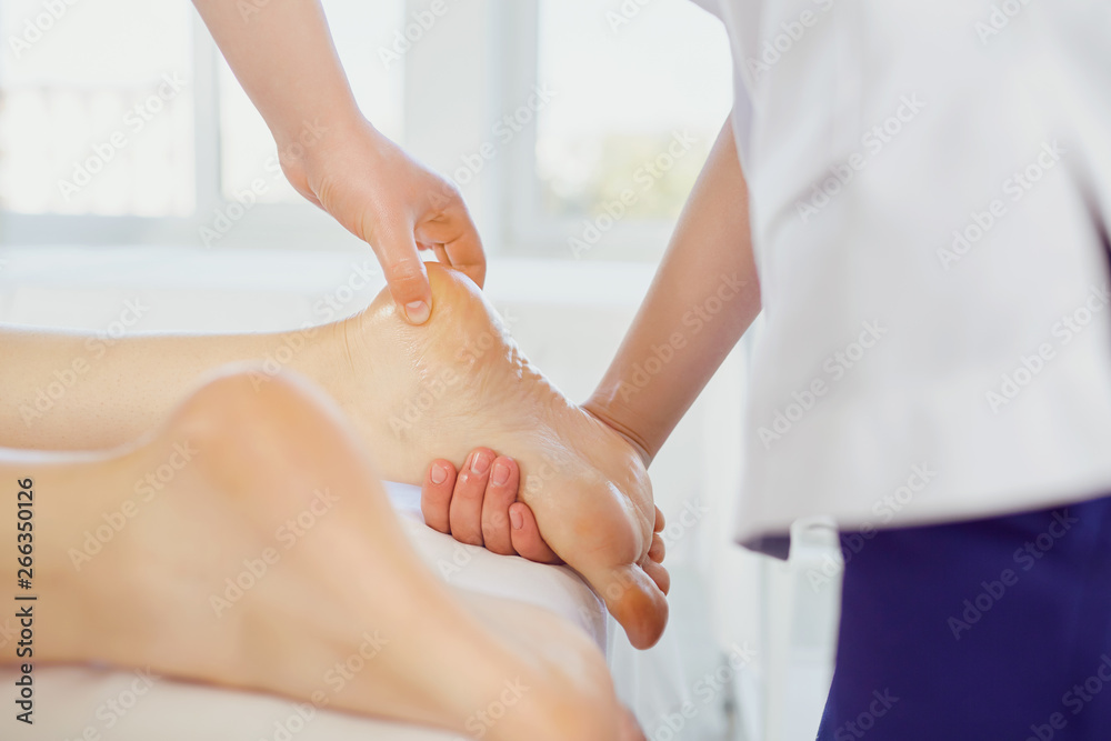 Fototapeta premium Crop master massaging feet of client