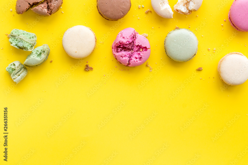 Fototapeta premium Macarons design on yellow background top view space for text