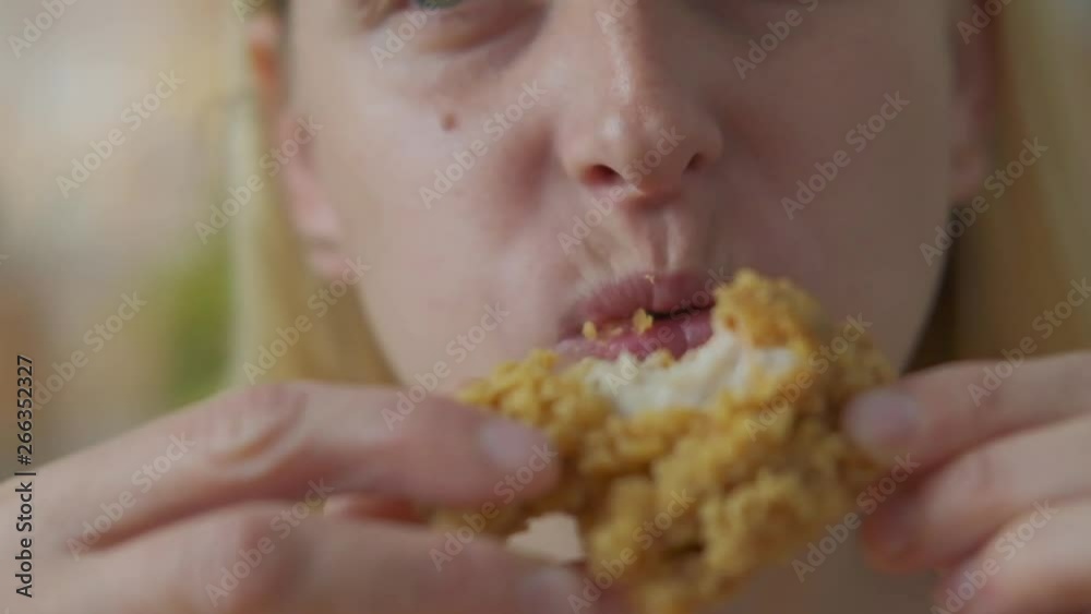 Young woman eating deep fried chicken - close up shot Young woman eating deep fried chicken - close up shot