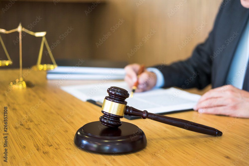 lawyer judge reading documents at desk in courtroom working on wooden desk background. gavel golden Weight. and soundblock of justice. lawyer judge reading documents at desk in courtroom working on wooden desk background. gavel golden Weight. and soundblock of justice.