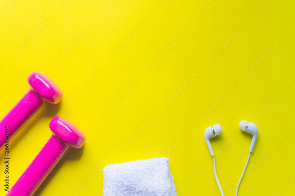 Obraz premium Fitness background, Equipment for gym and home dumbbell and Sneakers, earphone on color background. soft focus.