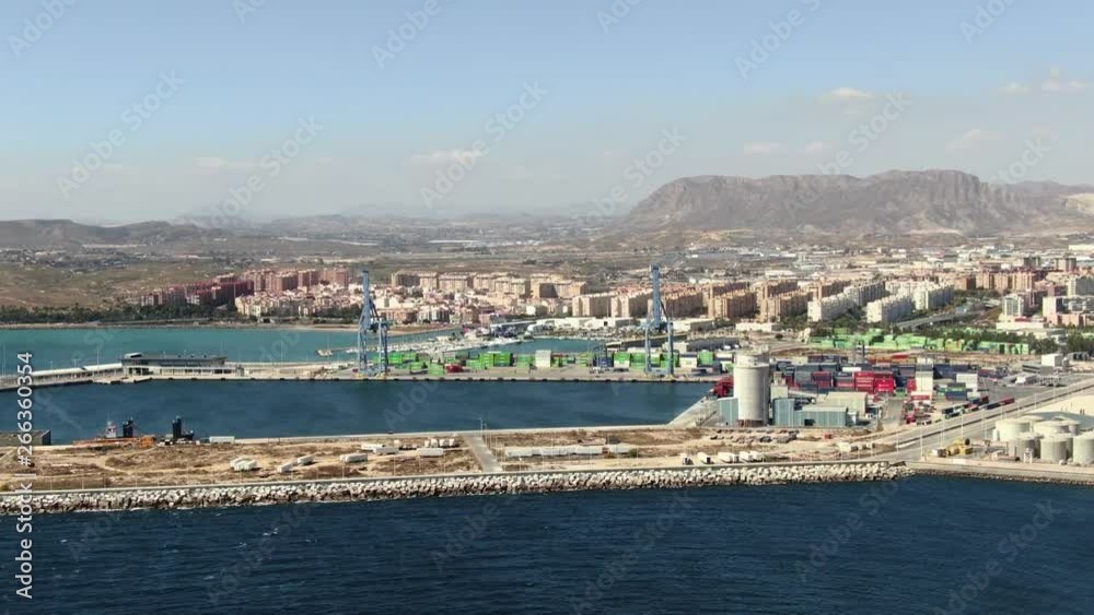 A beautiful wide slow-moving aerial shot of the Alicante harbor in Spain surrounded by the magnificent landscape and mountains on a beautiful summer day. Film LUT and grade added. A beautiful wide slow-moving aerial shot of the Alicante harbor in Spain surrounded by the magnificent landscape and mountains on a beautiful summer day. Film LUT and grade added.