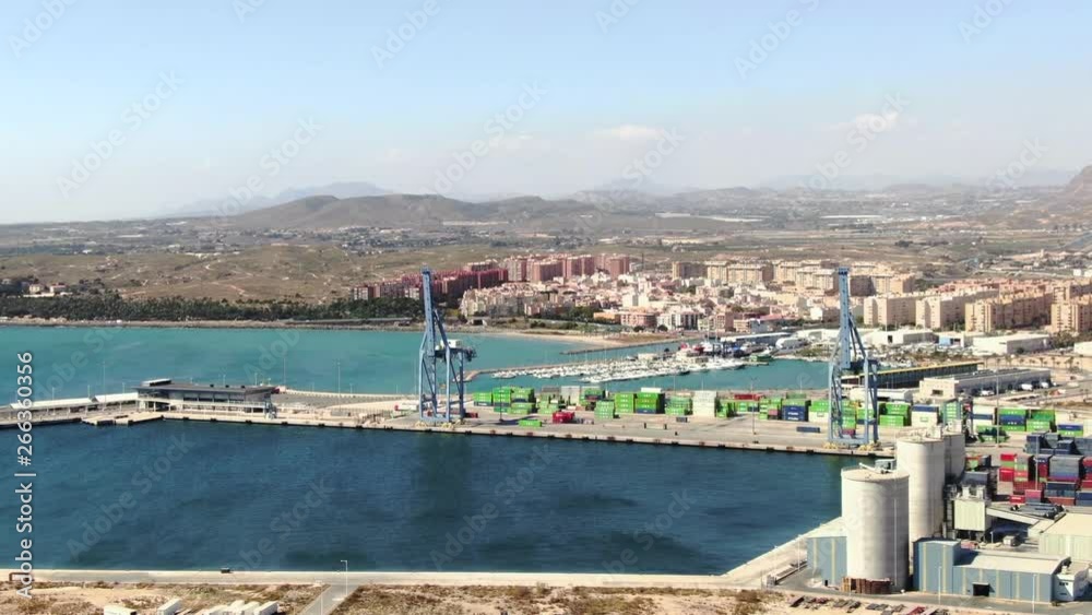 A beautiful wide slow-moving aerial shot of the Alicante harbor in Spain surrounded by the magnificent landscape and mountains on a beautiful summer day. Film LUT and grade added. A beautiful wide slow-moving aerial shot of the Alicante harbor in Spain surrounded by the magnificent landscape and mountains on a beautiful summer day. Film LUT and grade added.