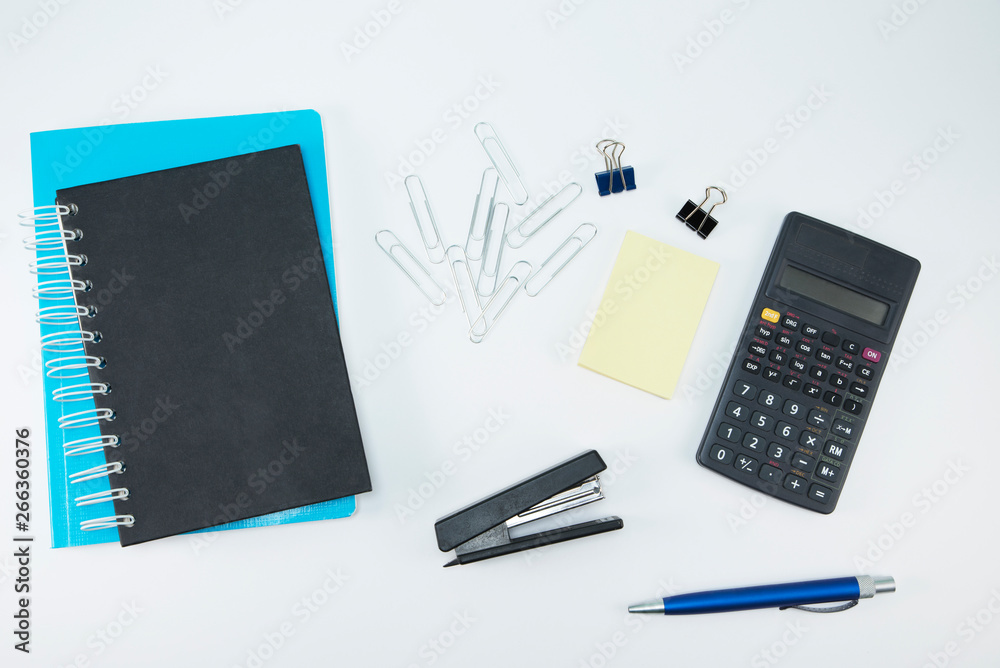 White office desk with calculator, notepad and sticker. Stationery on white background White office desk with calculator, notepad and sticker. Stationery on white background