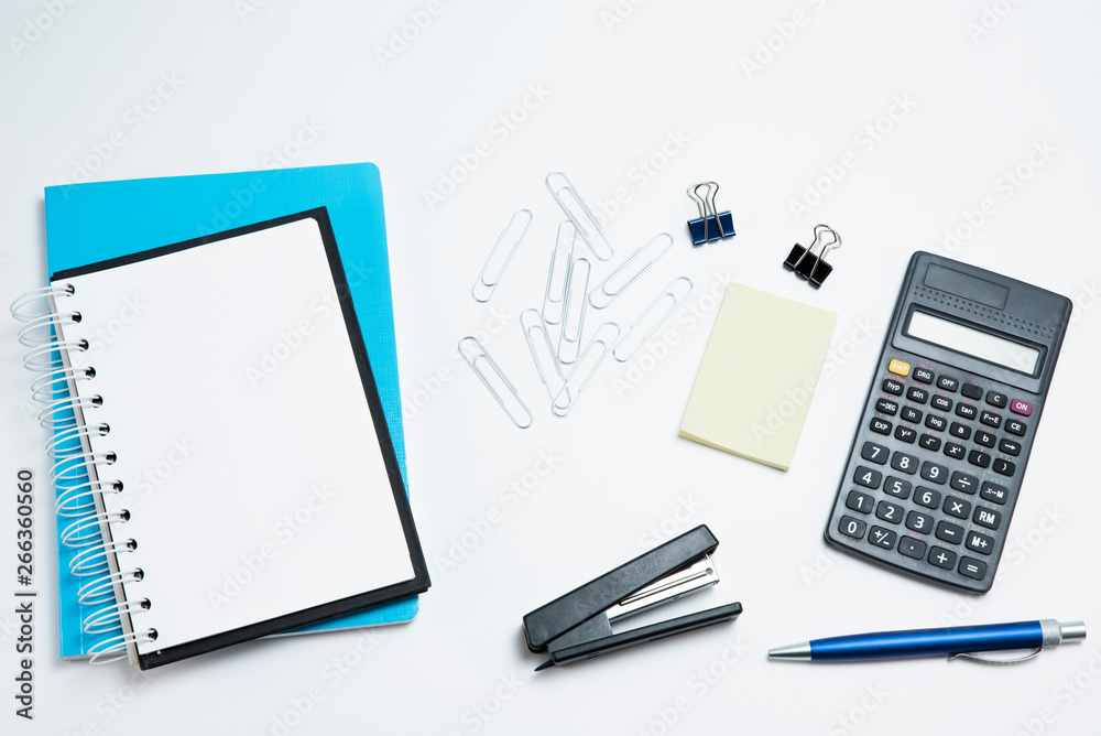 White office desk with calculator, notepad and sticker. Stationery on white background White office desk with calculator, notepad and sticker. Stationery on white background