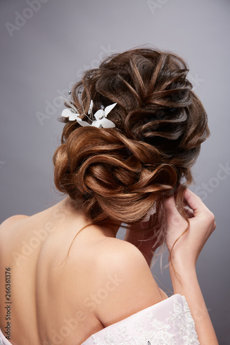 brides head with perfect hairstyle putting on earings