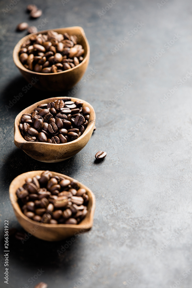 Three different varieties of coffee beans on dark vintage background