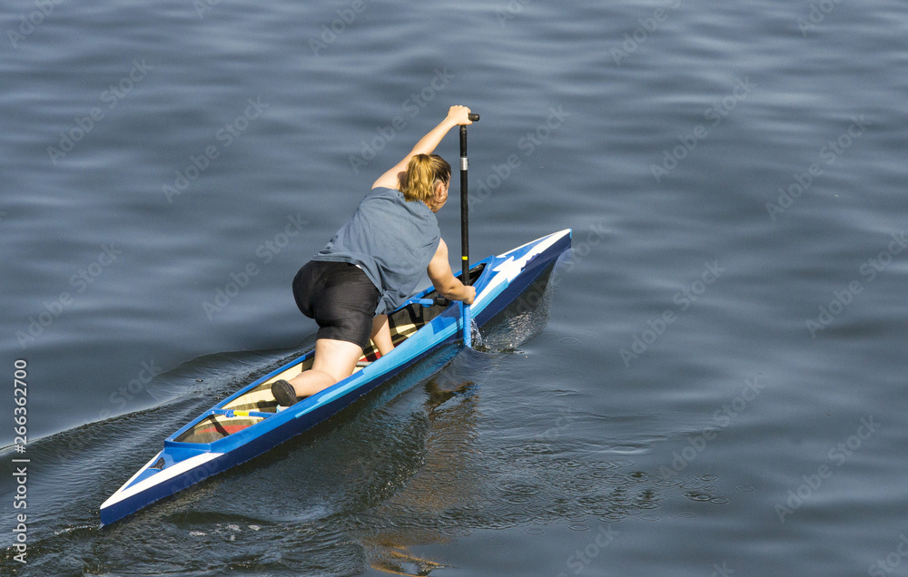 giovane ragazza in pantaloncini che rema in canoa