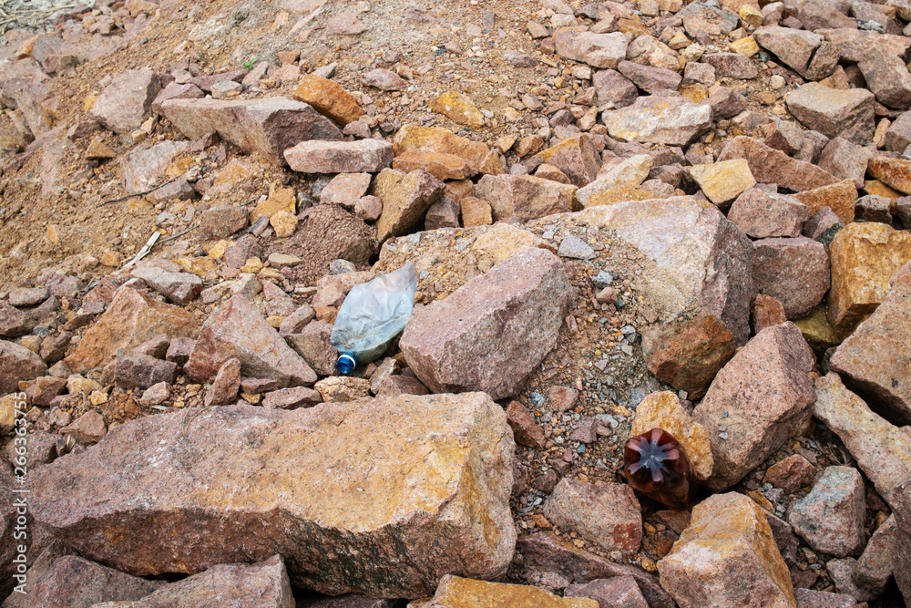 The world environmental pollution problem and issue with Garbage beach: Spilled garbage (rigid plastic bottles) on the rocky shore of the Kiev Sea The world environmental pollution problem and issue with Garbage beach: Spilled garbage (rigid plastic bottles) on the rocky shore of the Kiev Sea
