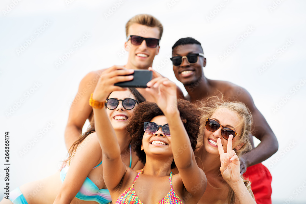 friendship, summer holidays and people concept - group of happy friends taking picture by smartphone on beach friendship, summer holidays and people concept - group of happy friends taking picture by smartphone on beach