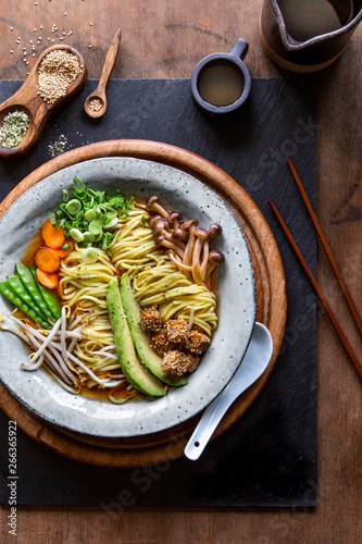 Vegan Japanese Ramen soup in grey bowl over wooden background photo