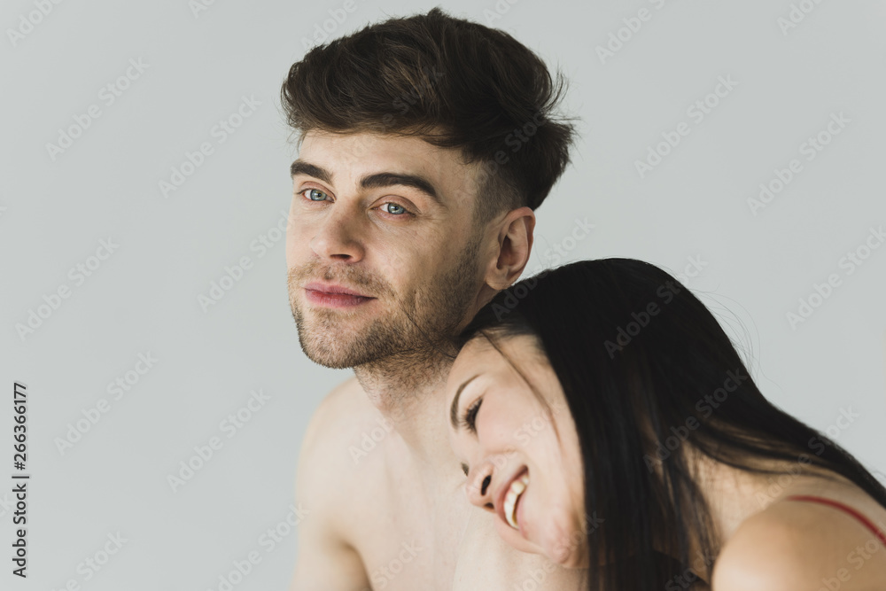 pretty, smiling asian woman putting head on dreamy boyfriends shoulder isolated on grey pretty, smiling asian woman putting head on dreamy boyfriends shoulder isolated on grey