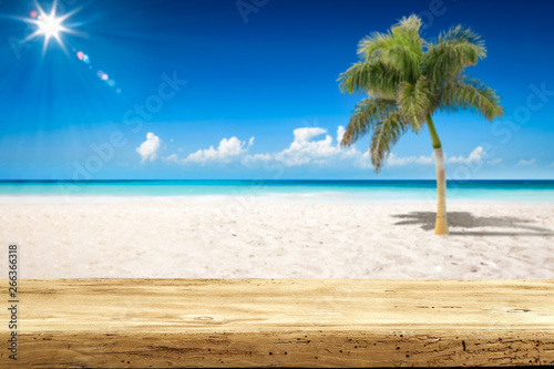 Desk of free space and summer background of ocean and beach with palm. Sunny day and blue sky. 