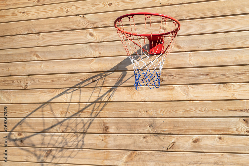 Basketball hoop hanged on wooden board background. Playground on backyard of home. Sport equipment for children