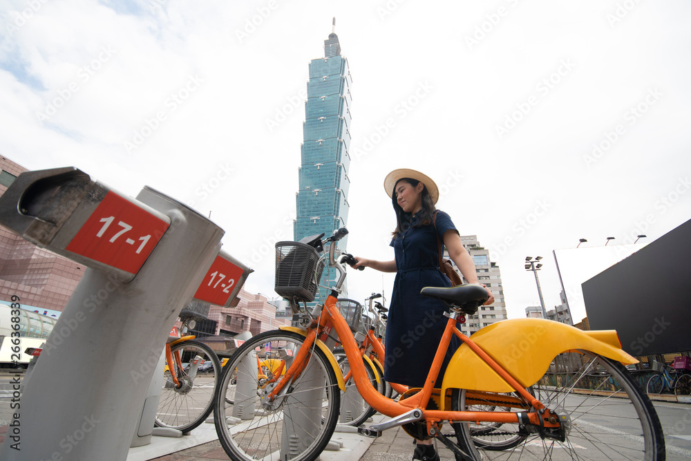 Fototapeta premium Beautiful Asian woman is going to rent bicycle in Taipei city, Taiwan.