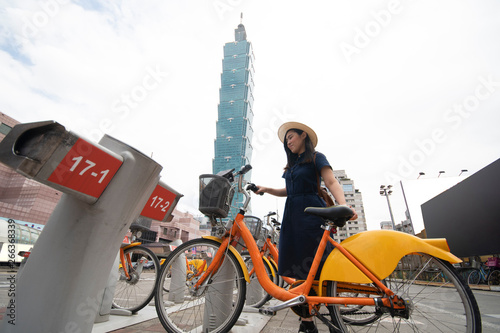 Beautiful Asian woman is going to rent bicycle in Taipei city, Taiwan.