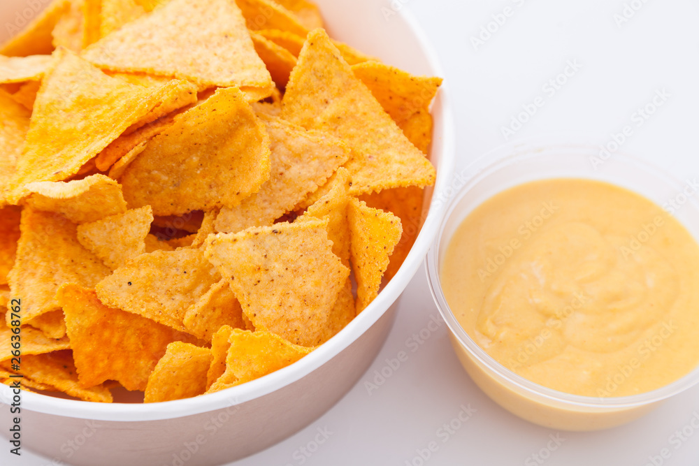 Mexican nachos with creamy cheese sauce. Delicious salty corn chips triangular nachos snack for party