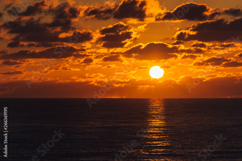 Fototapeta Naklejka Na Ścianę i Meble -  orange sky as glowing sun rises over the ocean