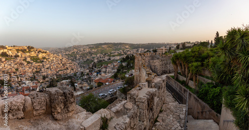 Beautiful panoramic view of the Walls of Jerusalem surrounding the Old City with the cityscape in the background during a sunny sunset. Taken near the Jerusalem  Israel.
