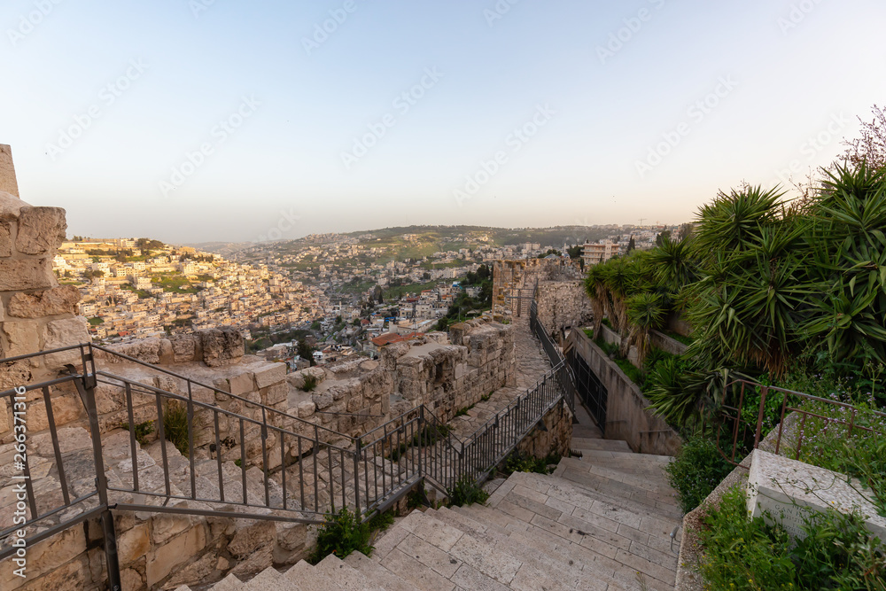 Beautiful view of the Walls of Jerusalem surrounding the Old City with the cityscape in the background during a cloudy day. Taken near the Jerusalem, Israel. Beautiful view of the Walls of Jerusalem surrounding the Old City with the cityscape in the background during a cloudy day. Taken near the Jerusalem, Israel.