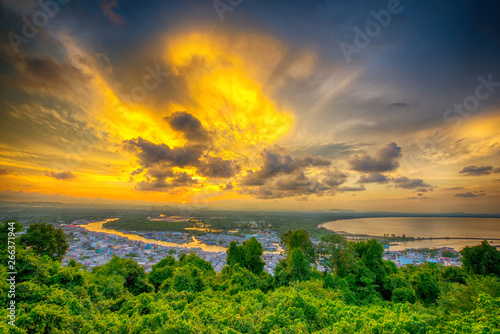 Clouds of beautiful color in the summer sunset, Dark Clouds, Natural beautiful cloudscape over the sea with sunlight background and green forest in the foreground at Ban Pak Nam, Chumphon, Thailand.