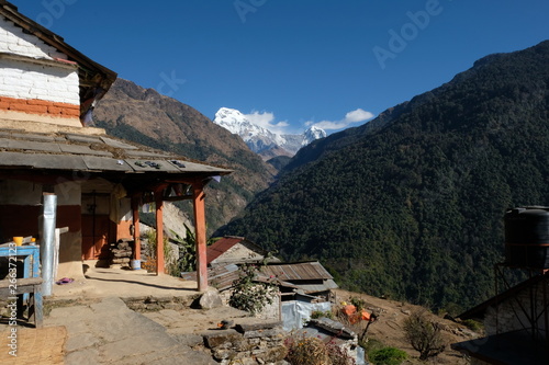 Stunning mountain home in the Nepali himalayas of the Annapurna range. Snow capped mountain backdrop.