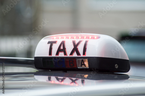 closeup of taxi sign on car parked in the street