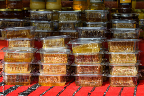 Bee honeycombs in individual plastic boxes available for sale at a street food market