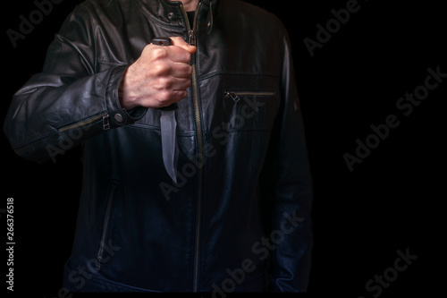 A man in a black leather jacket with a knife in his hand